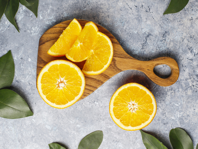 Апельсин на разделочной доске кусочками