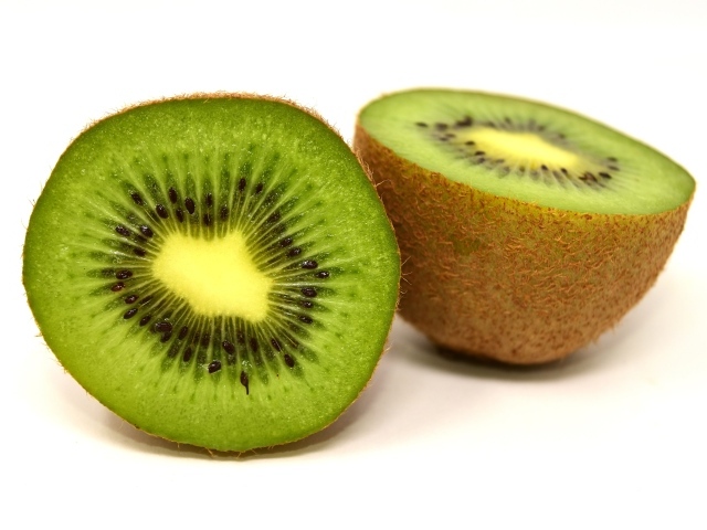 Две половинки киви на белом фоне