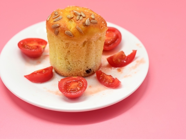 Кекс с помидорами черри на белой тарелке