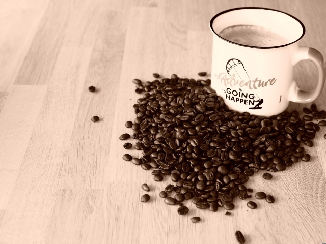 Чашка кофе на деревянном столе с кофейными зернами