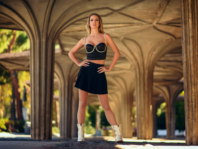 Красивая девушка в черном наряде позирует для фото 