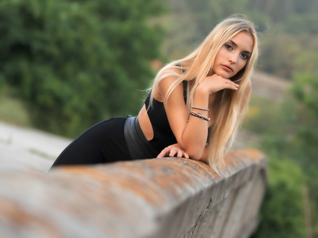 Красивая длинноволосая блондинка с браслетами на руке