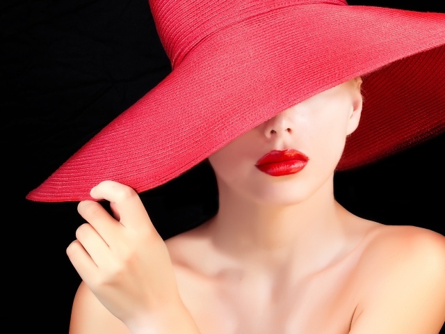 Девушка в большой красной шляпе на черном фоне