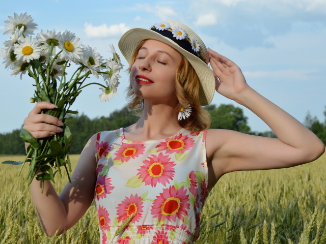 Девушка с букетом ромашек на поле