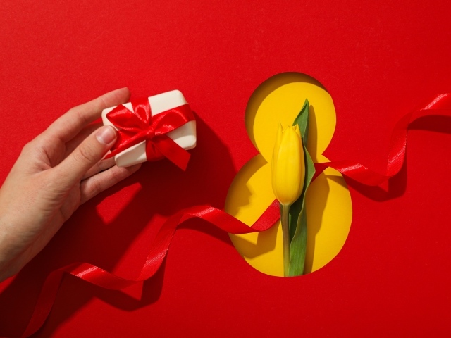 Красный фон с подарком, желтым тюльпаном и цифрой на 8 марта