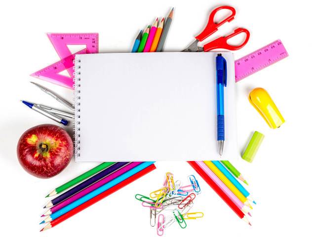 Много канцелярии с блокнотом и яблоком на белом фоне