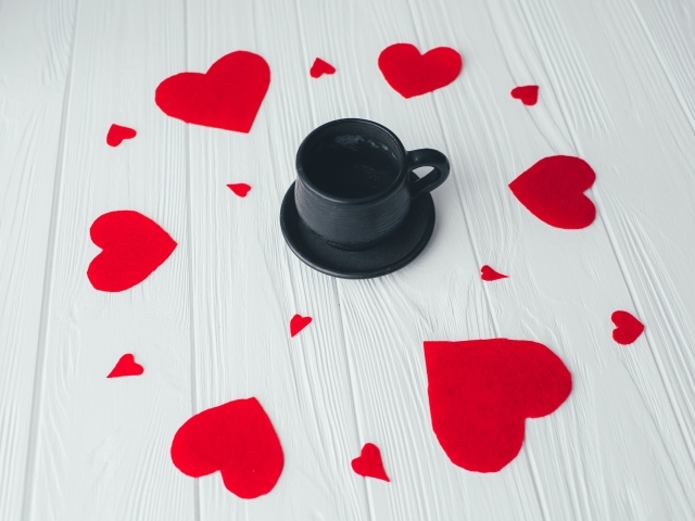 Чашка кофе с красными сердечками на столе