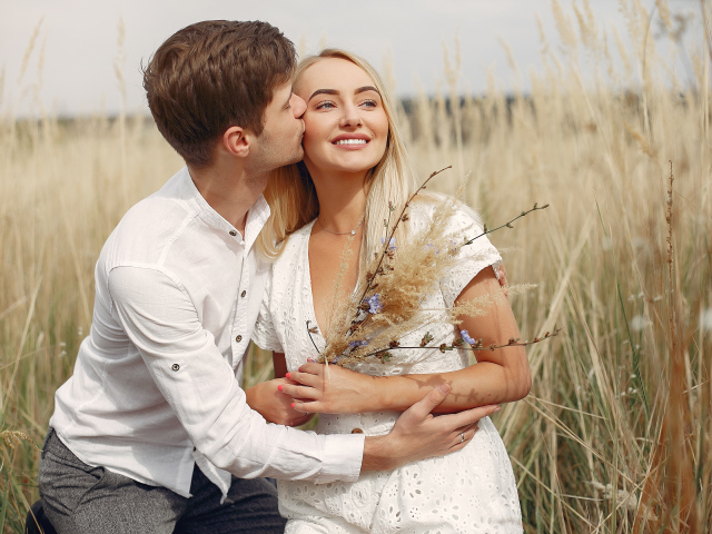 Поцелуй красивой пары на поле