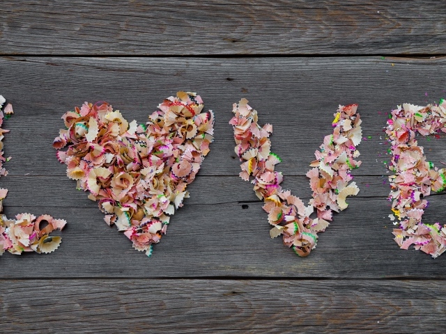 Надпись любовь из стружки карандашей на деревянном фоне