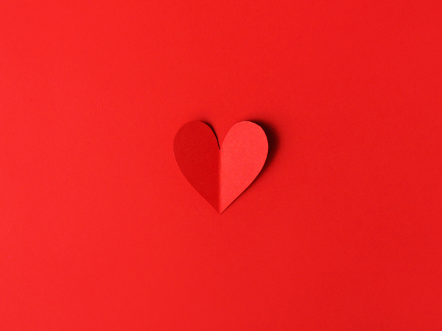 Маленькое бумажное сердце на красном фоне