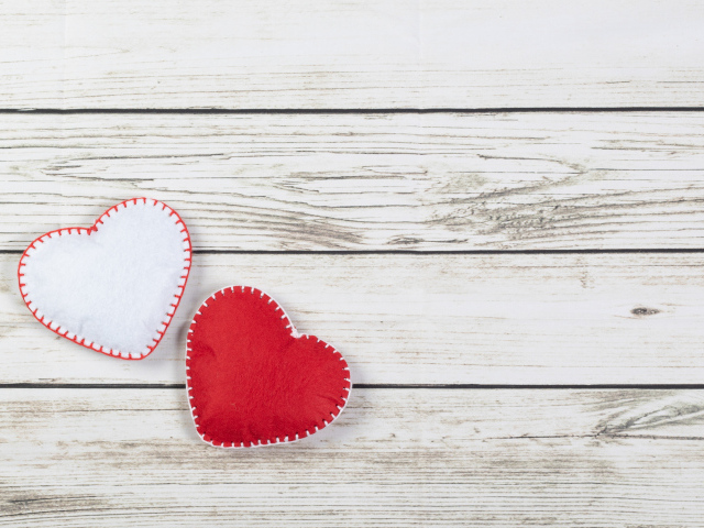 Белое и красное сшитое сердце на деревянном фоне