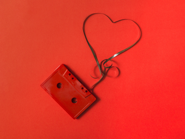 Кассета с сердцем из ленты на красном фоне