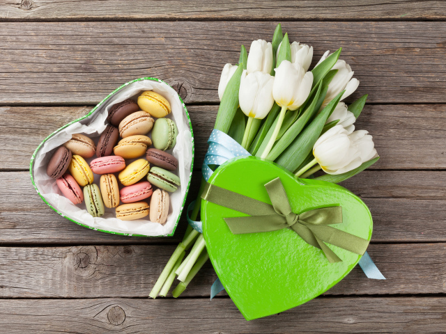 Букет белых тюльпанов на столе с коробкой печенья макарун