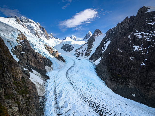 Заснеженная заледеневшая дорога между гор