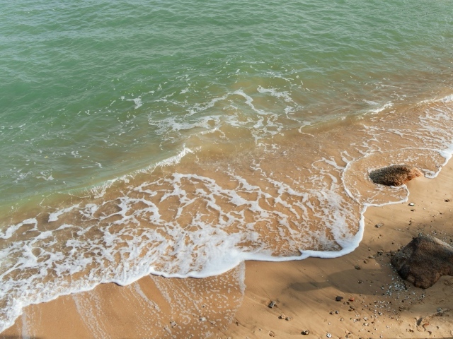 Красивая бирюзовая морская вода с белой пеной на песке
