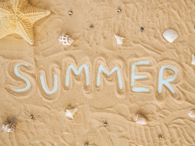 Надпись лето на песке с ракушками