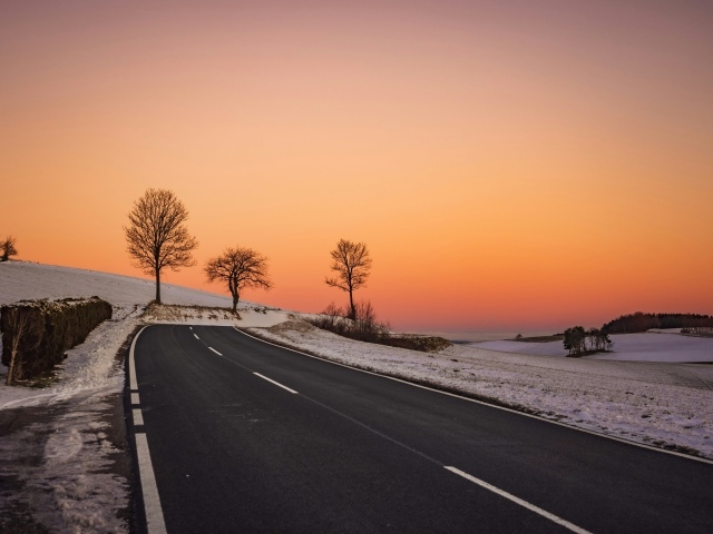 Дорога на фоне красного заката зимой