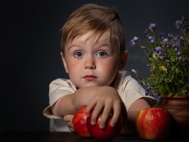 Маленький голубоглазый мальчик с яблоками