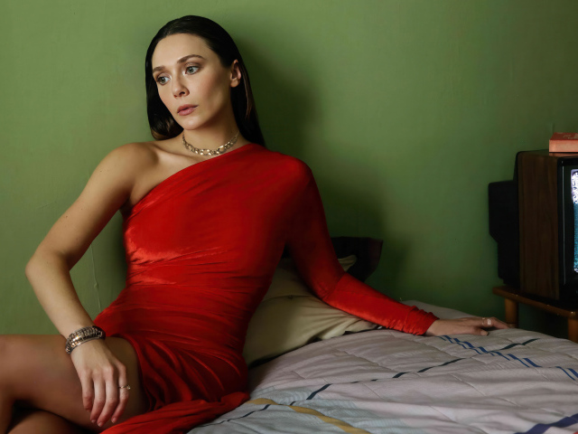 Актриса Элизабет Олсен в красном платье сидит на кровати