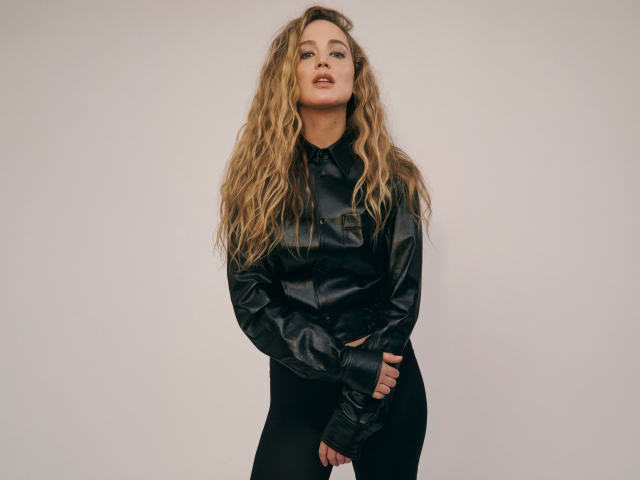 Актриса Дженнифер Лоуренс  в черном костюме на сером фоне