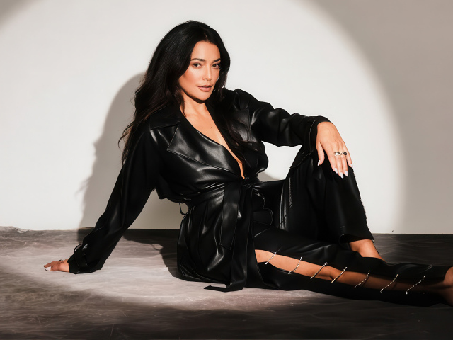 Актриса Натали Мартинес в черном кожаном костюме на фоне серой стены