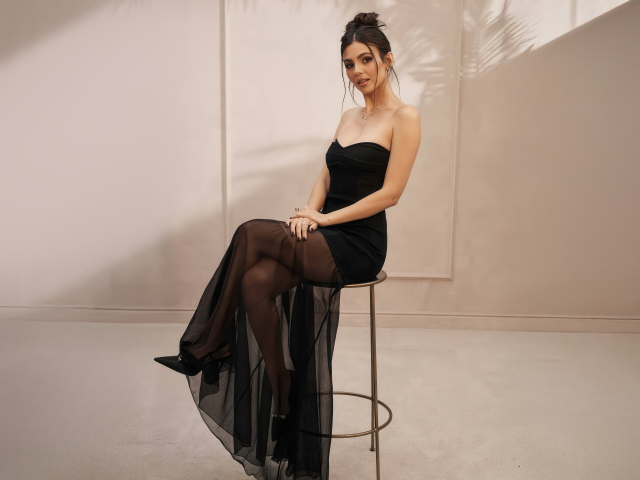 Американская актриса Виктория Джастис в черном платье на стуле