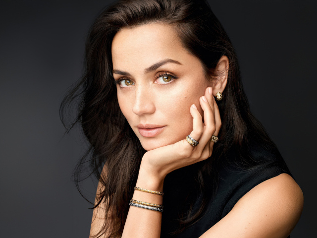 Кареглазая девушка актриса Ана де Армас на сером фоне