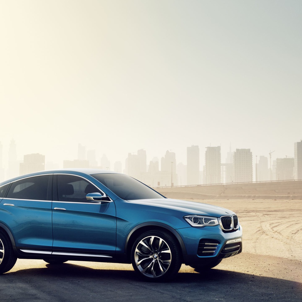 The blue BMW X4 crossover on the city landscape
