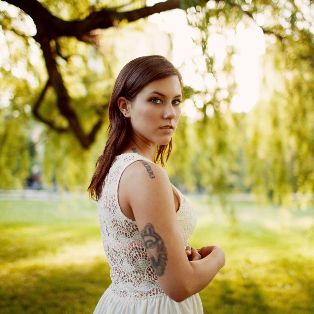 Брюнетка с татуировкой на природе