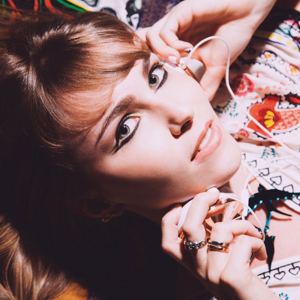 Девушка лежит с наушниками