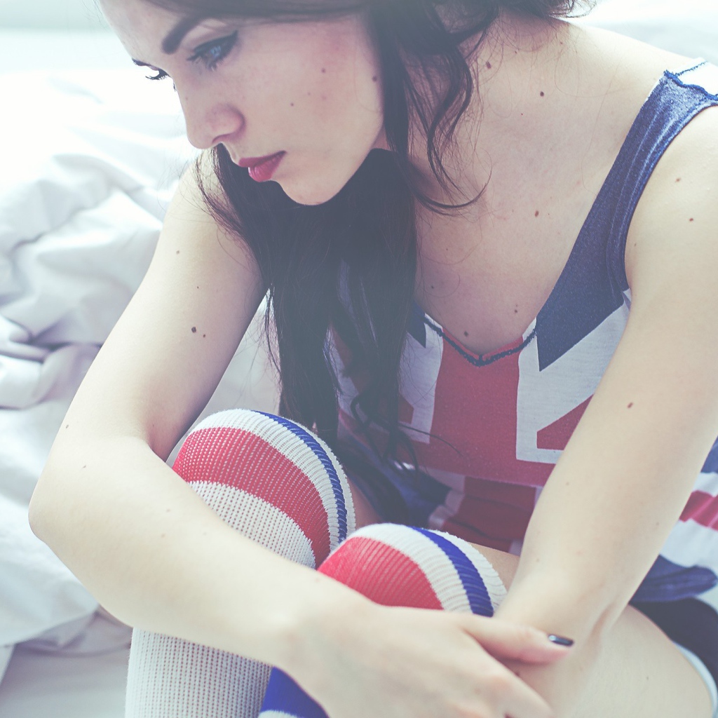 Девушка грустит на кровати