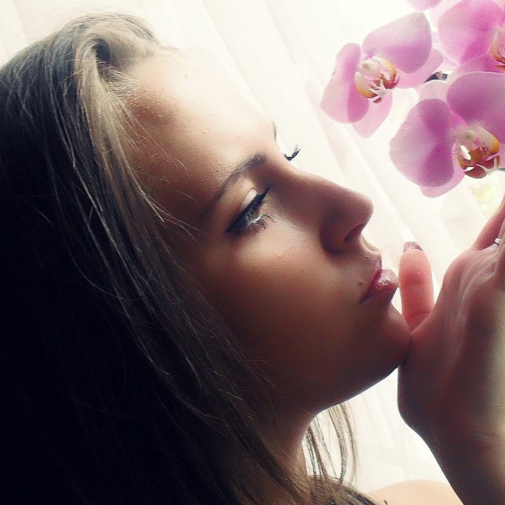 Девушка смотрит орхидею