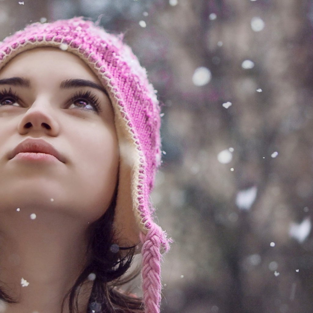 Девушка смотрит на падающий снег