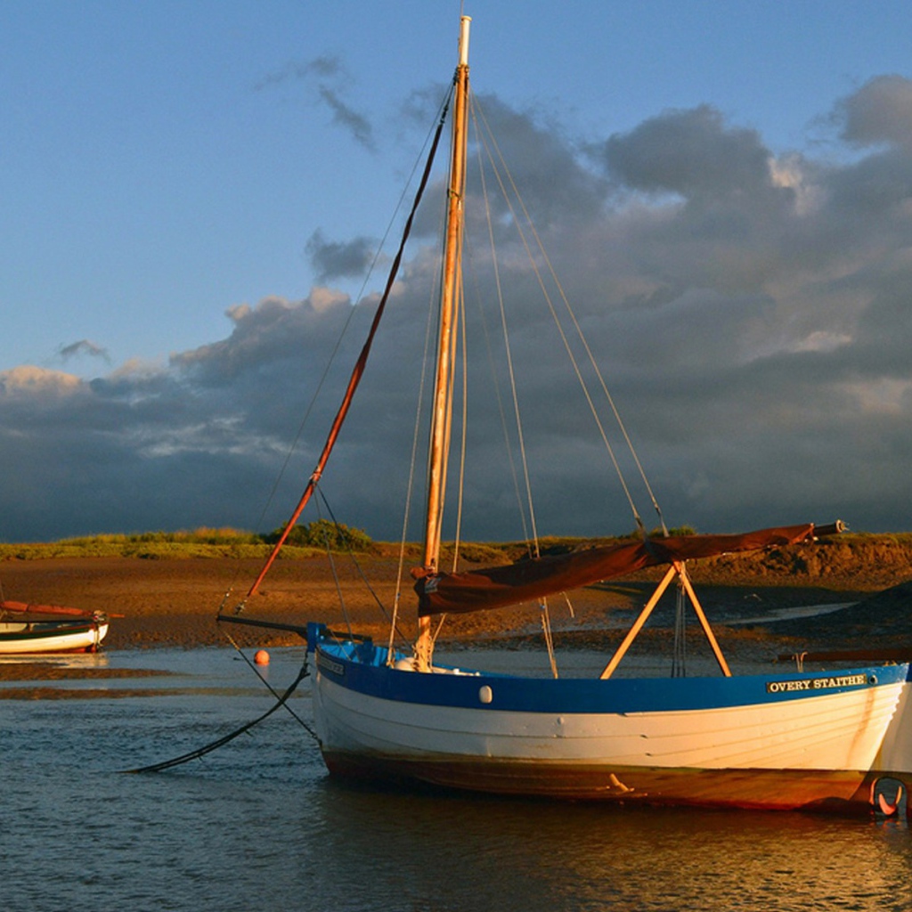 Парусная лодка стоит у берега