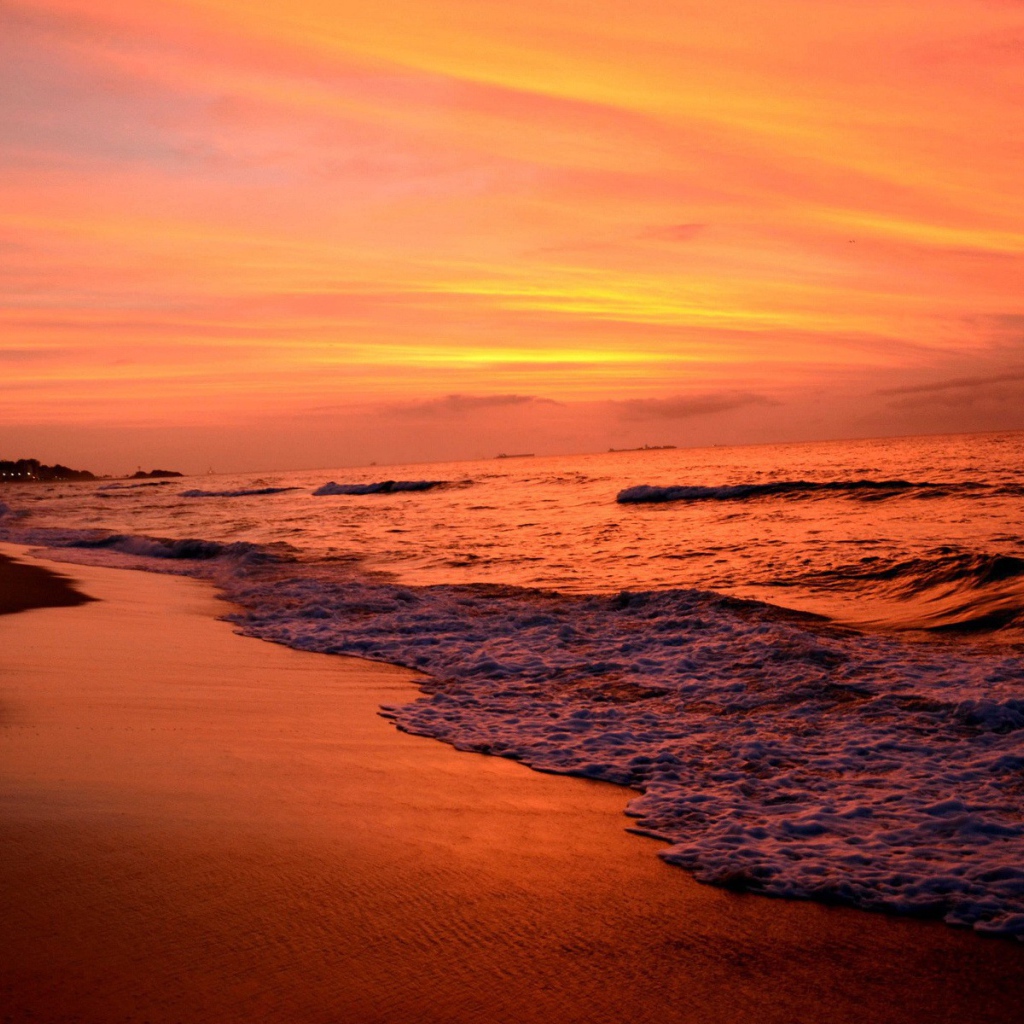 На закате волны лижут пляж