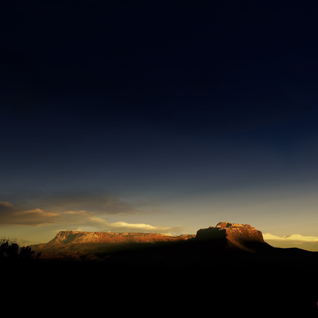 Солнце на закате освещает гору