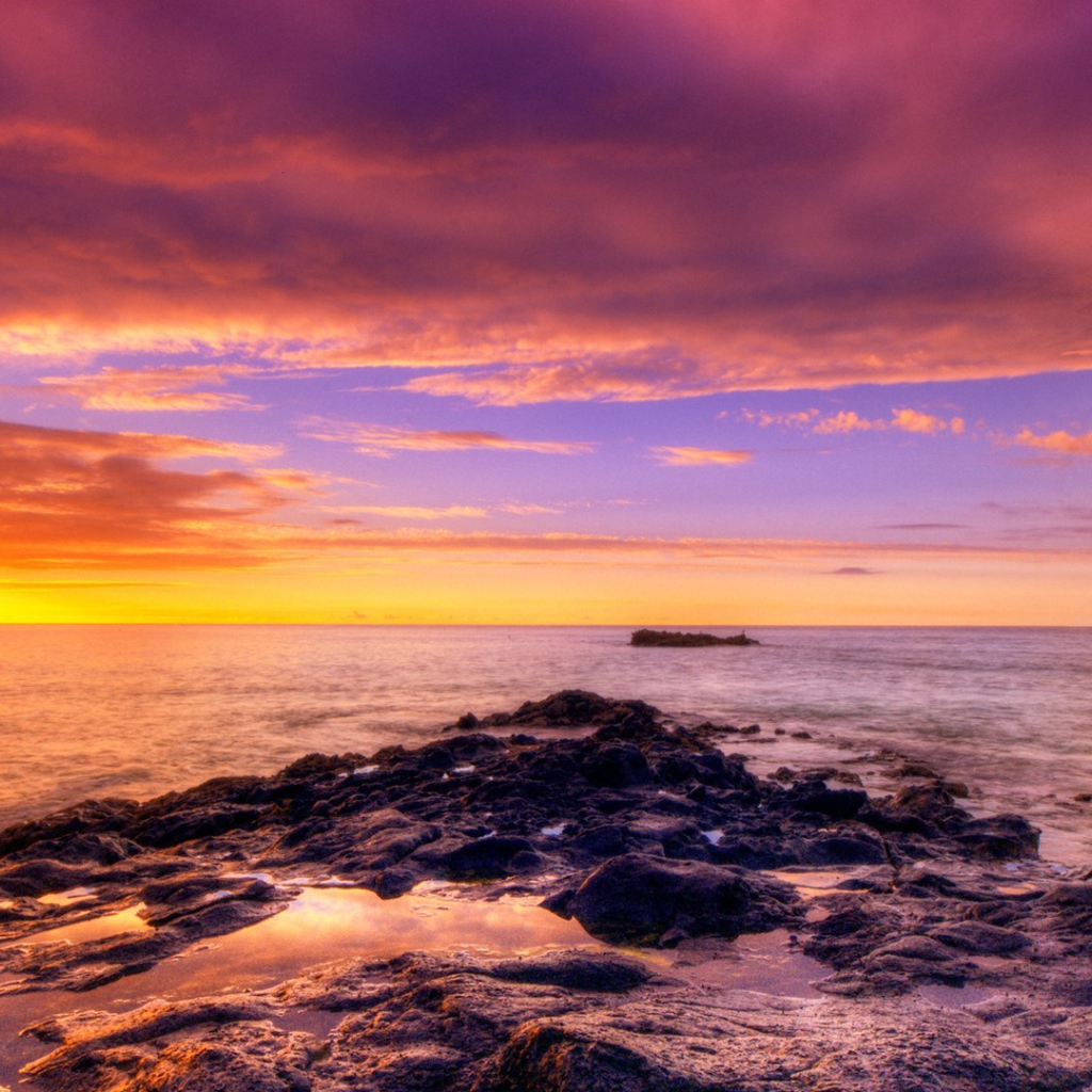 Разноцветный закат на каменистом побережье