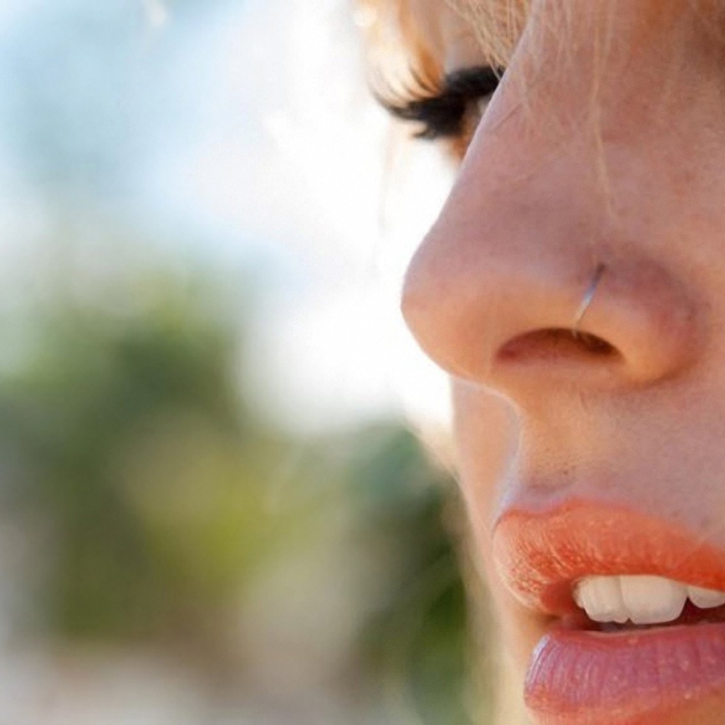 Девушка блондинка с пирсингом в носу крупным планом