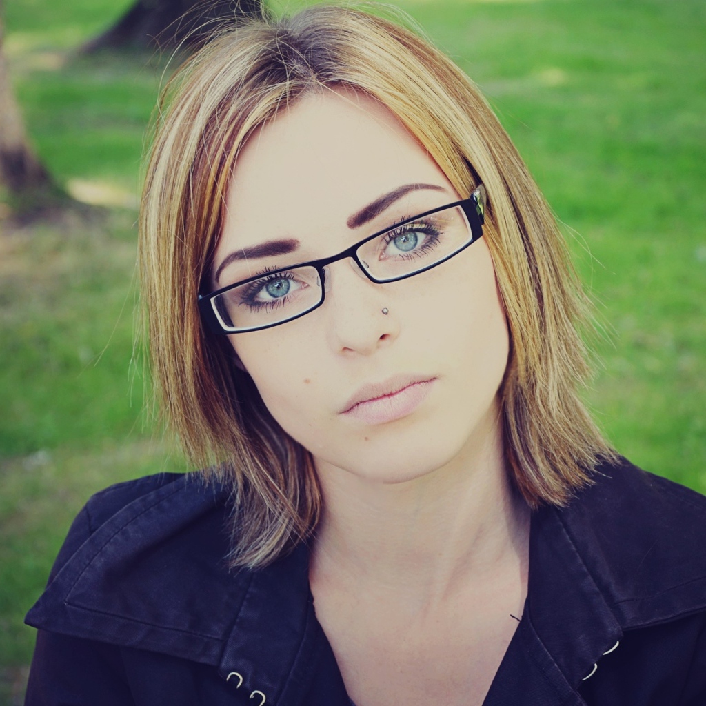 Девушка блондинка с пирсингом в носу в очках