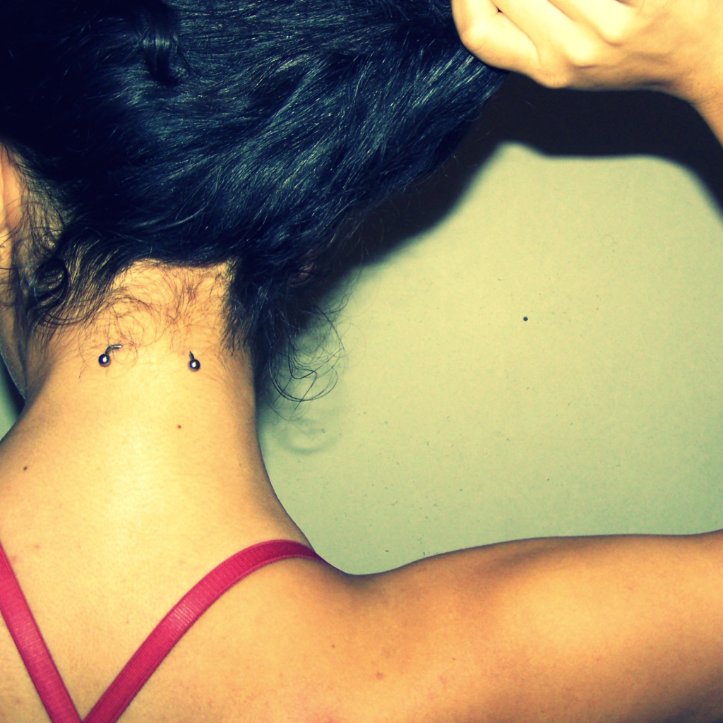 Девушка брюнетка с пирсингом в шее