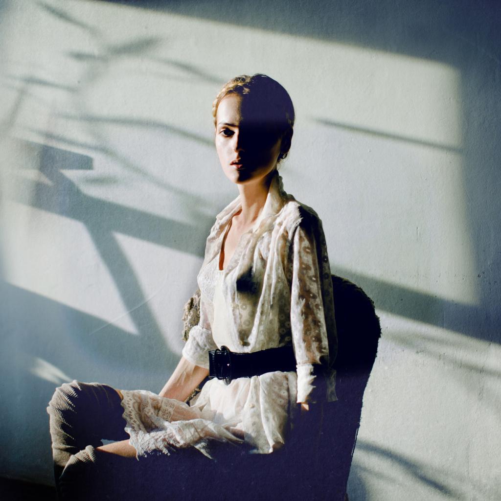 Фотография девушки на фоне белой стены