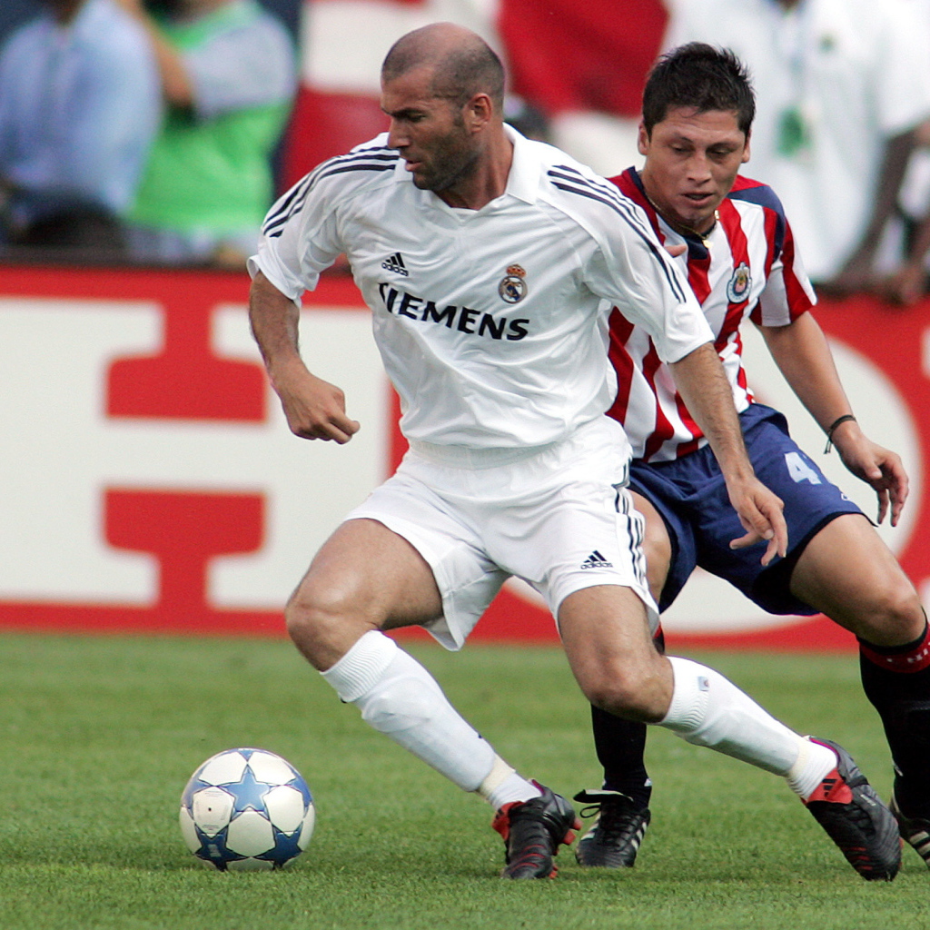 Легенда футбола Зинедин Зидан передавая мяч