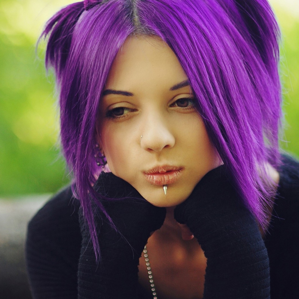 Молодая девушка с пирсингом в носу и губах