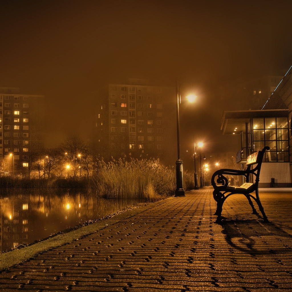 Скамейка около реки в городе