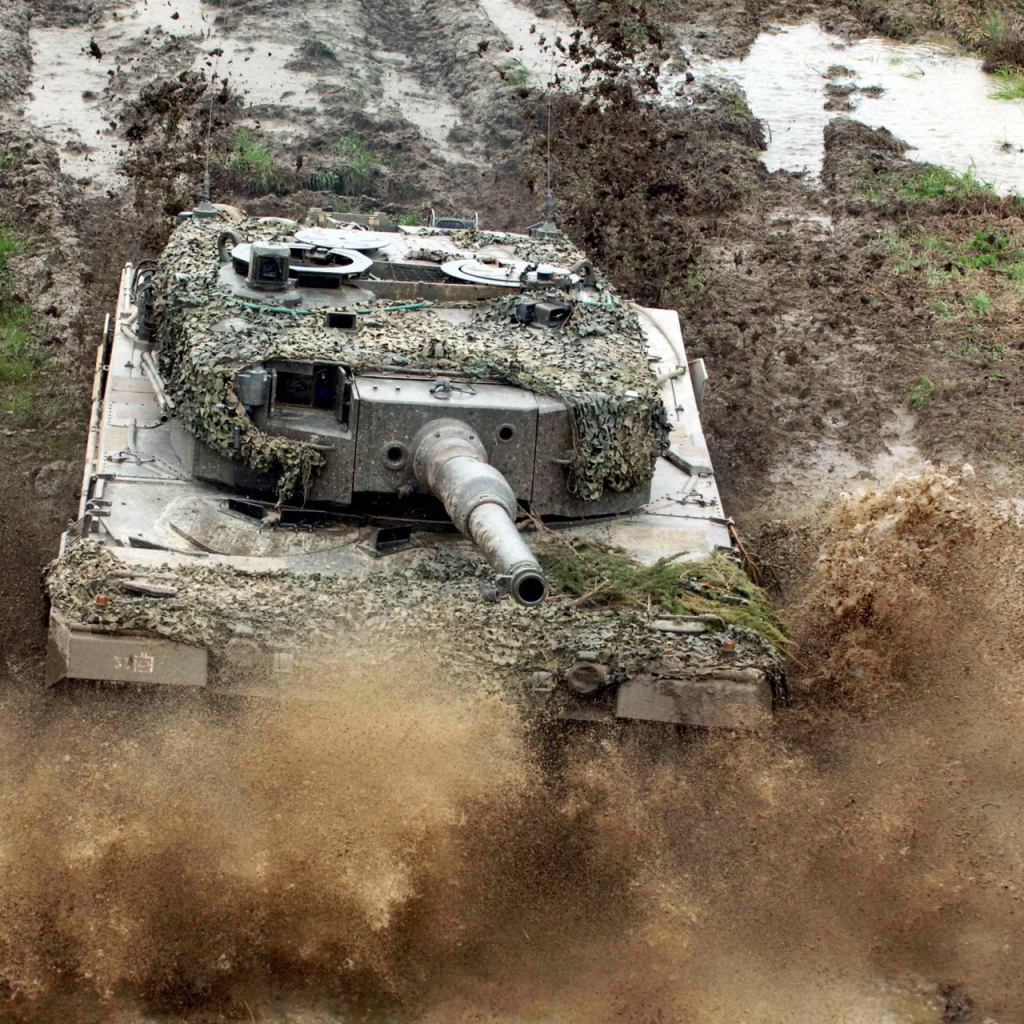 Танк в маскировке едет по грязи