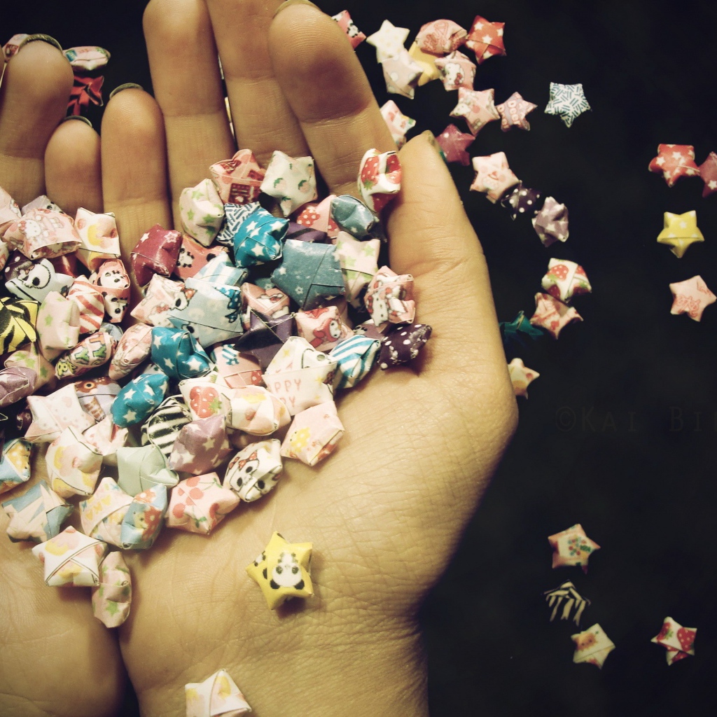 На ладонях оригами звездочки