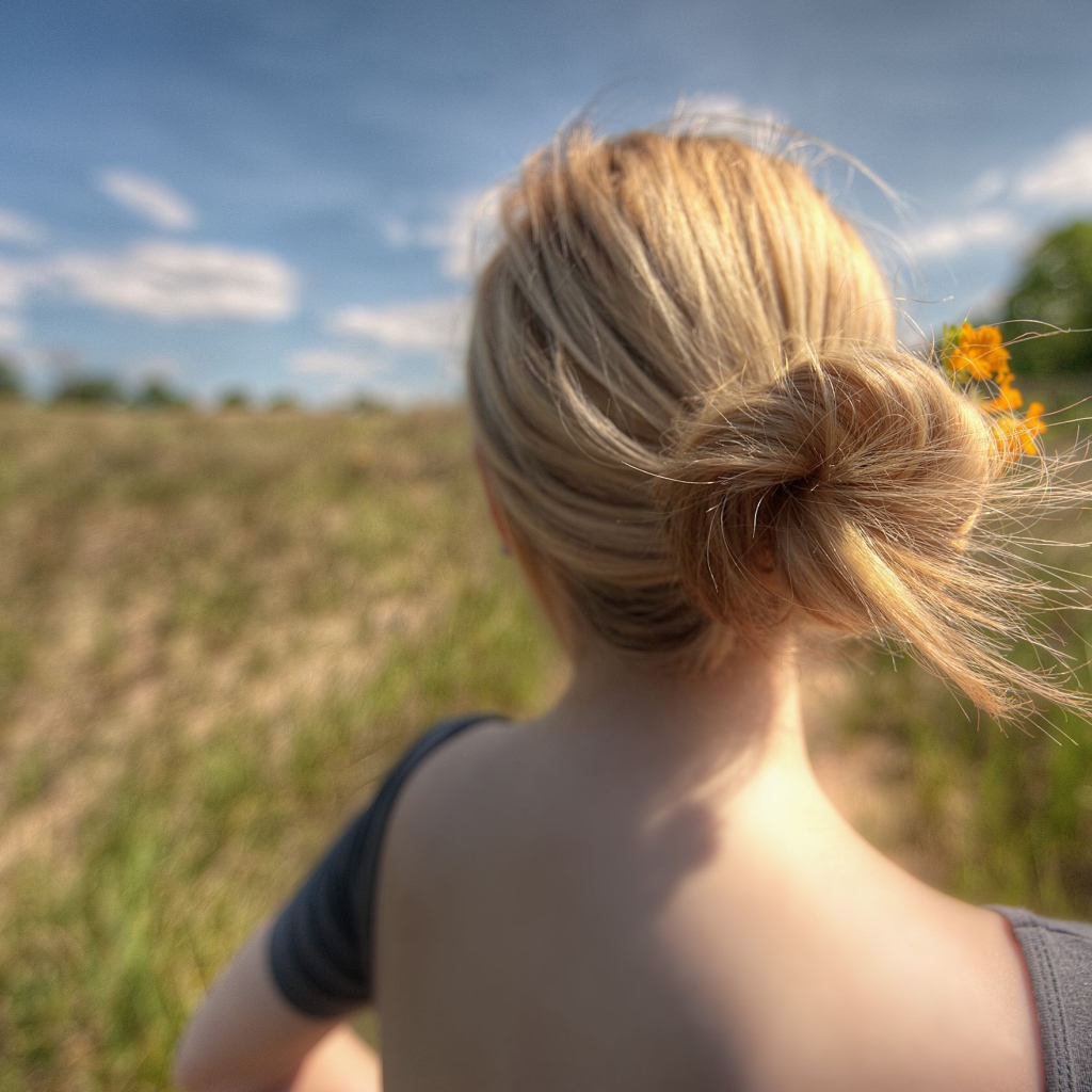 Девушка с цветами в волосах в поле