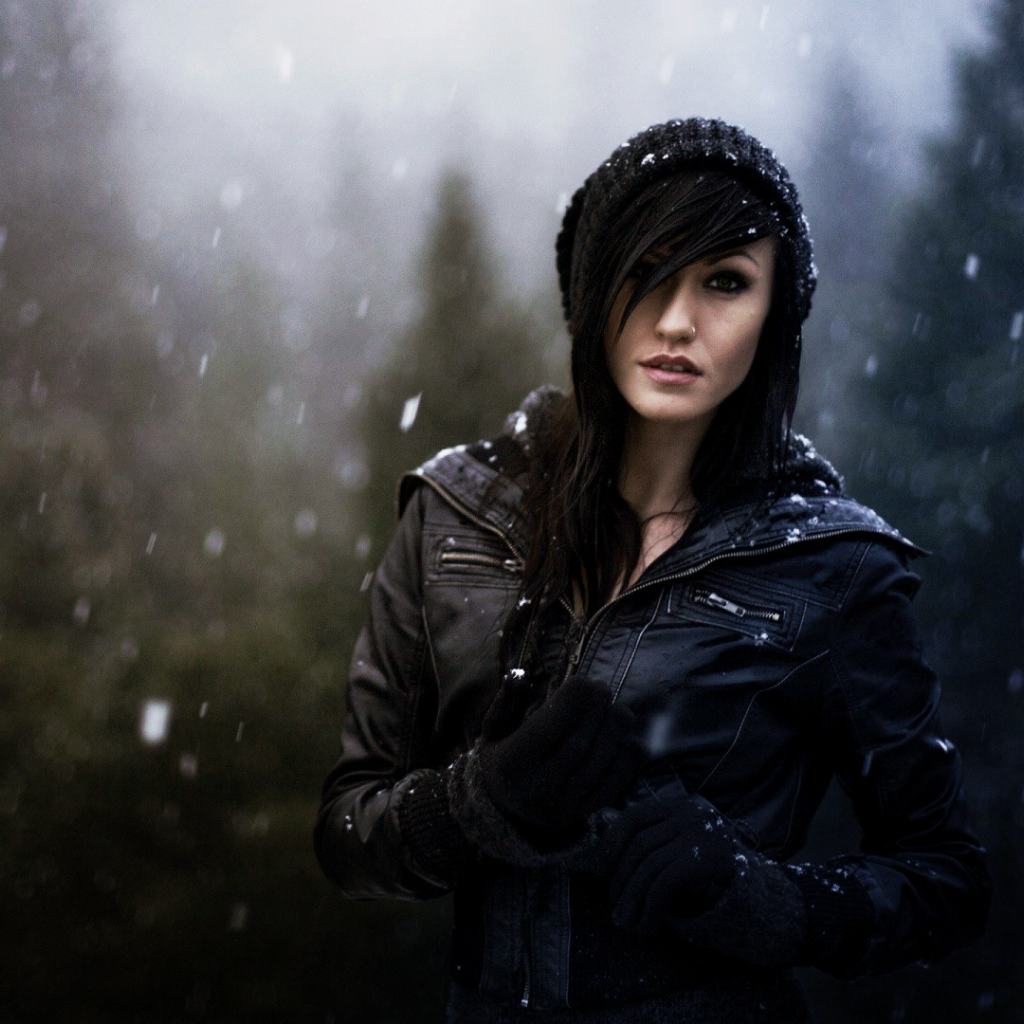 Брюнетка в куртке под снегом