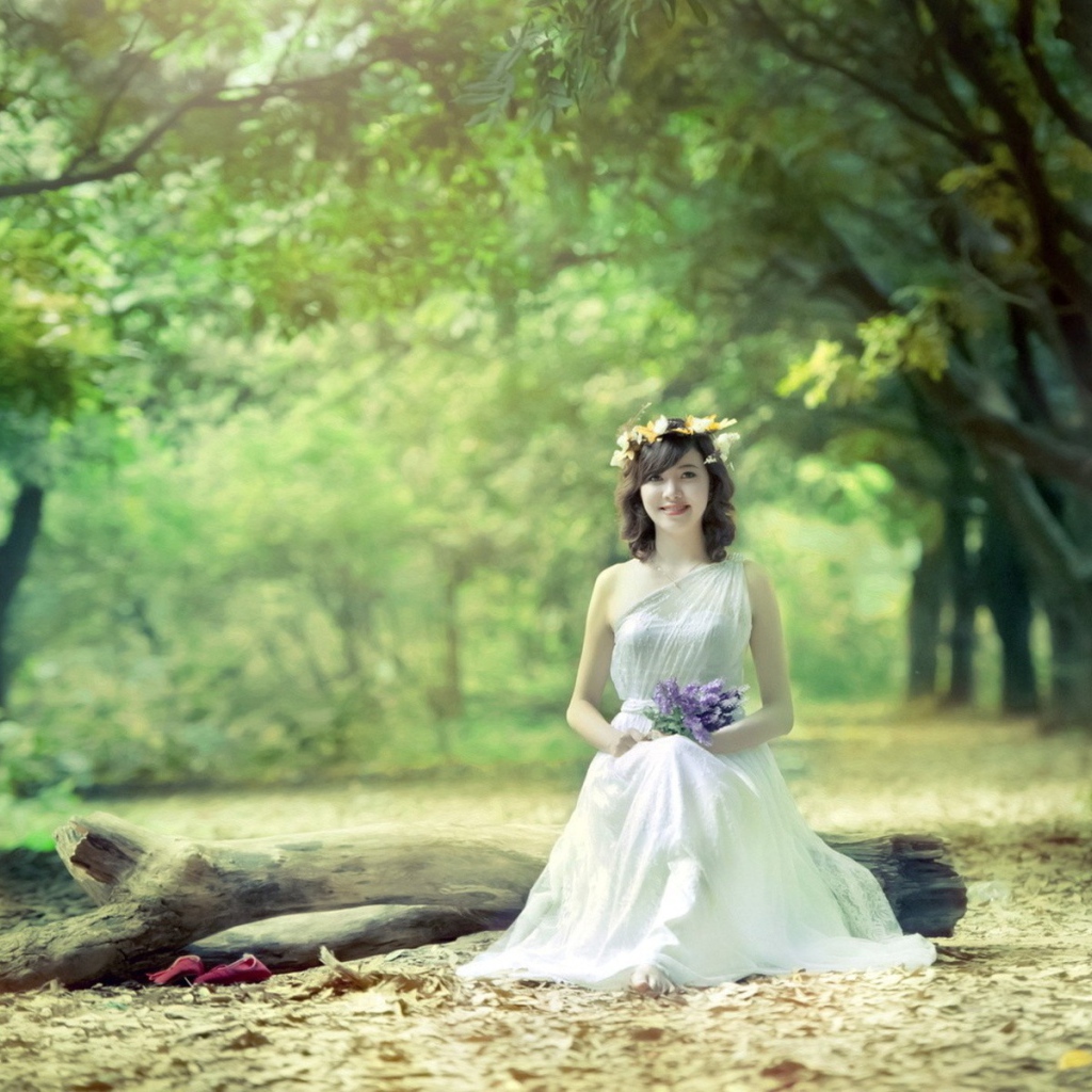 Девушка сидит на бревне