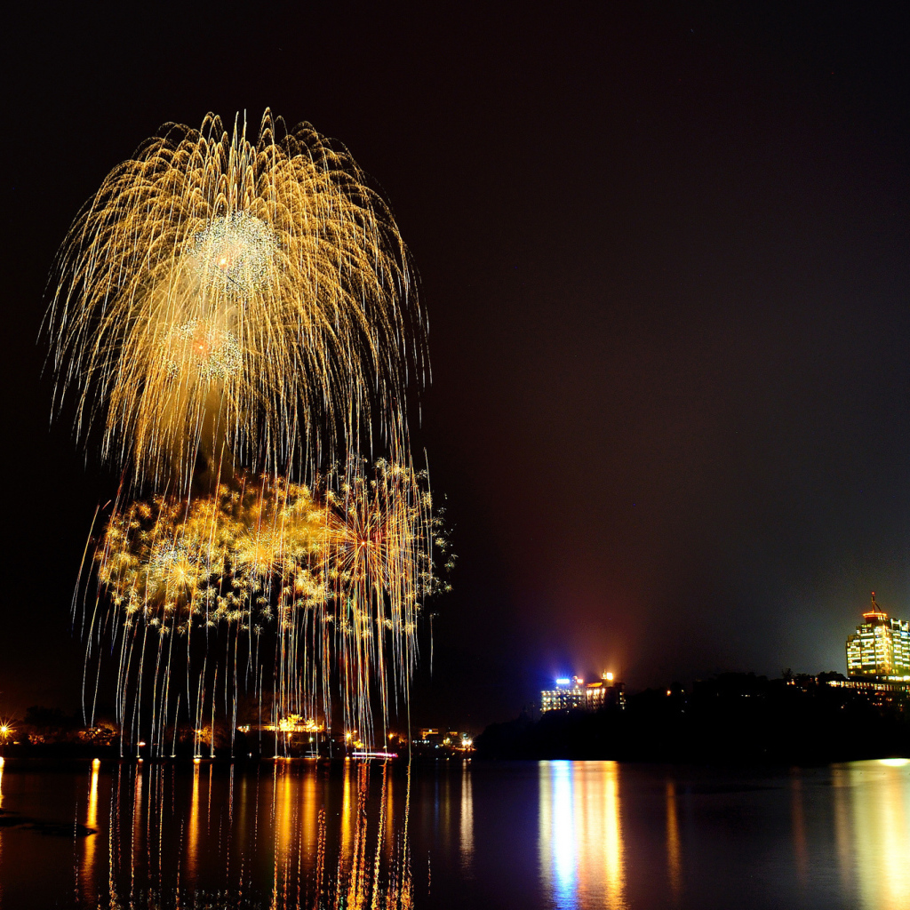 Праздничный фейерверк отражается в воде